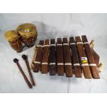 A wooden handmade xylophone and a set of bongo drums.