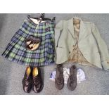 A kilt in Campbell tartan with a leather sporran with metal studs by Broadsword with a green jacket,