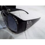 Swarovski - a pair of sunglasses with Swarovski crystal detailing still with tags with a Swarovski