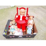 Dolls - a vintage dressed doll with glass eyes and jointed limbs sitting in a wooden high chair,