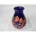 Moorcroft Pottery - a medium sized bulbous vase hand painted with anemone on a cobalt blue ground,