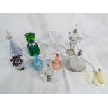 A collection of nine glass perfume bottles of varying shapes and designs