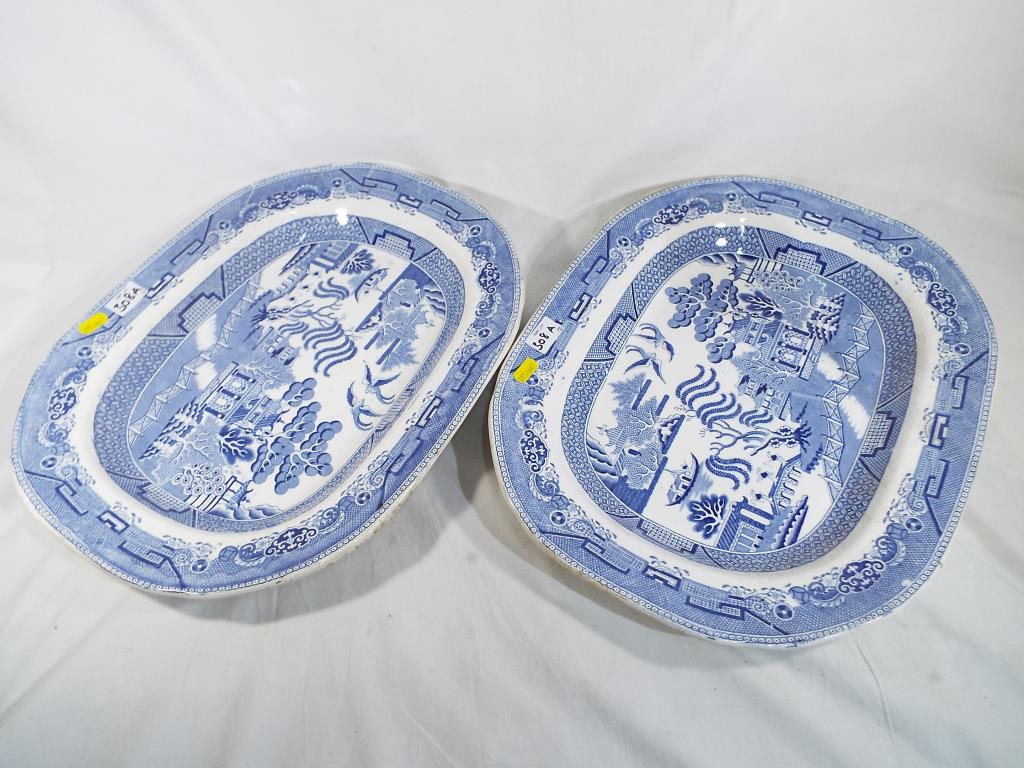 A pair of large blue and white "Willow Pattern" ashettes.