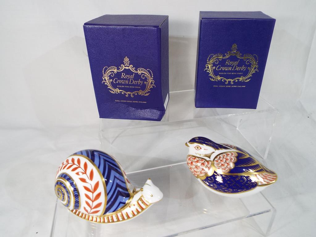 Royal Crown Derby - two paperweights depicting a Snail and a Quail,