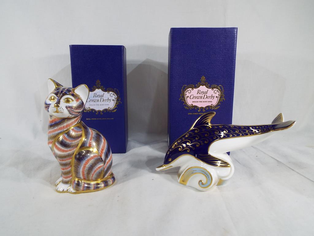 Royal Crown Derby - two paperweights by Royal Crown Derby depicting a dolphin and a cat,