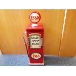 An Esso petrol pump with shelves,