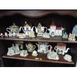 Two shelves containing a quantity of ceramic novelty teapots, Lilliput Lane cottages,