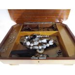 A musical wooden carved jewellery table containing a quantity of jewellery,