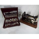 A vintage Singer sewing machine marked V534014 and a cased canteen of cutlery