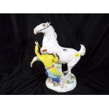 A Meissen ceramic figurine of a Turk holding a rearing horse, approximately 25 cm (h) (AF).