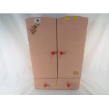 A vintage child's miniature play wardrobe containing doll's clothes and similar,