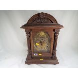 An oak cased bracket style chiming clock,