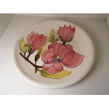 Moorcroft Pottery - a large charger decorated with pink magnolia, WM monogram to base,