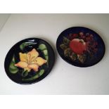 Moorcroft Pottery - two coasters of which one depicting a Bluefinch, the other an Orchid,