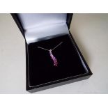 A lady's 9 carat white gold pink sapphire drop pendant and fine chain, approx 1.