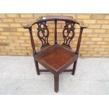 An antique oak pierced back corner chair