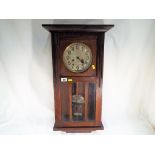 A mahogany cased wall clock, silvered dial an pendulum bob, glazed opening door,