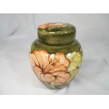 Moorcroft Pottery - a large covered ginger jar decorated with pink coral hibiscus on a green ground,