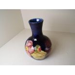 Moorcroft Pottery - a bulbous vase decorated with clematis on a blue ground,