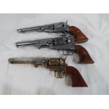 Three replica percussion pistols two in the form of Colt navy pistols and one in the form of a Colt