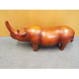 A good quality leather footstool in the form of a rhino, 48 cm x 89 cm.