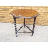 An oak octagonal shaped top carved occasional table on barley twist supports.