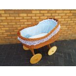 A good quality wicker crib supported on