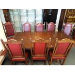 A good quality heavy carved oak extending dining table with eight chairs with leather upholstered