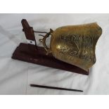 A brass Buddhist prayer bell with wooden hanger and striker.