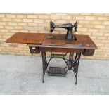 A Singer sewing machine on stand with cast iron legs model No.