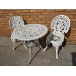 A good quality wrought iron garden table and two matching chairs,