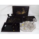 A collection of ebony items to include, 3 decorated trays, 2 candlesticks, trinket box and similar,