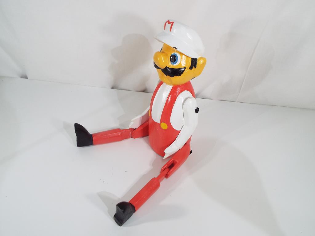 A good quality carved wooden hand-painted shelf puppet depicting Mario.