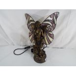 A good quality table lamp in the form of a fairy with decorative wings in a Tiffany style.