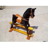 A good quality Mamas and Papas child's rocking horse on wooden base,