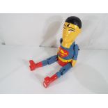 A carved hand-painted Superman shelf puppet.