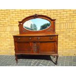 An oak mirror backed sideboard with two drawers and two cupboards,