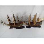 2 models of warships on wooden plinths.