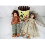 Two vintage dressed dolls and a vintage tin containing two further smaller dolls