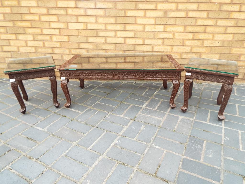 An Indian carved teakwood coffee table and two matched side tables,