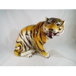 A large ceramic figure depicting a seated Tiger,