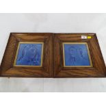 A pair of oak framed Majolica style blue tiles,