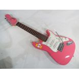 A child's electric guitar by Encore in pink