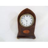 An Edwardian inlaid mahogany cased arched mantel clock, Roman numerals on a white dial,