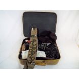 A vintage suitcase containing a quantity of clothing to include hats, gloves,