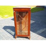 A single door glazed display cabinet wit