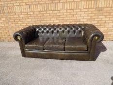 A three seater Chesterfield sofa in olive green,