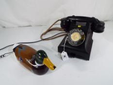 A 1940s bakelite telephone with wheel dial and sliding drawer,