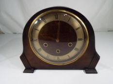 An oak cased mantle clock Roman numerals on a silvered chapter ring,