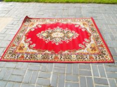 A good quality floor rug decorated on a red ground,
